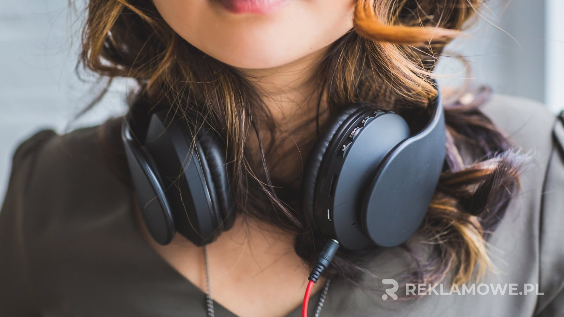 Osoba korzystająca ze słuchawek podczas nagrywania podcastu